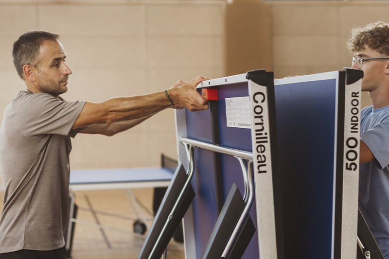2 personnes qui ouvrent la table de ping pong Cornilleau 500 indoor